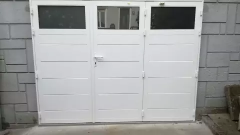 Porte de garage battante avec hublots